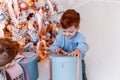 Twin brothers in front of the christmas tree with candles and gifts. love, happiness and big family concept Royalty Free Stock Photo