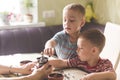 Twin brothers helping her mother to grind coffee