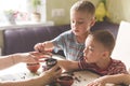 Twin brothers helping her mother to grind coffee