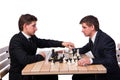 The twin brothers playing chess on white Royalty Free Stock Photo