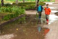 Twin brothers run through a puddle