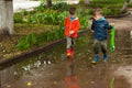 Twin brothers run through a puddle