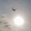 Twin-engine airliner ATR 72 against the bright sun. Royalty Free Stock Photo