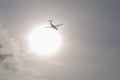 Twin-engine airliner ATR 72 against the bright sun. Royalty Free Stock Photo