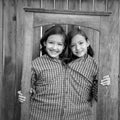 Twin girls fancy dressed up pretending be siamese in frame Royalty Free Stock Photo