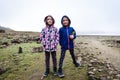 Twin girls standing on remains of ancient roman ruins stone