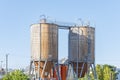 Twin industrial towers for waste collection, storage and disposal against a backdrop of clear blue skies Royalty Free Stock Photo