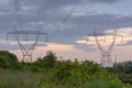 Twin Power Line Towers with Cloudy Sky During Sunset Royalty Free Stock Photo