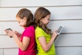 Twin sister girls playing with tablet pc happy on white wall Royalty Free Stock Photo