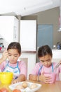 Twin Sisters Beating Eggs in Kitchen Royalty Free Stock Photo