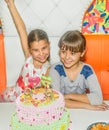 Twin sisters at birthday celebration with cake Royalty Free Stock Photo