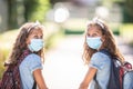 Twin sisters with face mask back at school during COVID-19 quarantine