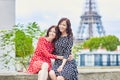 Twin sisters in front of the Eiffel tower in Paris, France Royalty Free Stock Photo