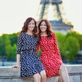 Twin sisters in front of the Eiffel tower in Paris, France Royalty Free Stock Photo