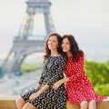 Twin sisters in front of the Eiffel tower in Paris, France Royalty Free Stock Photo