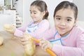 Twin Sisters Peeling Potatoes in Kitchen Royalty Free Stock Photo