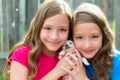 Twin sisters and puppy pet dog chihuahua playing Royalty Free Stock Photo