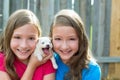 Twin sisters and puppy pet dog chihuahua playing Royalty Free Stock Photo