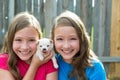 Twin sisters and puppy pet dog chihuahua playing Royalty Free Stock Photo