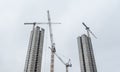 Twin skyscrapers under construction. Building site with multiple tower cranes