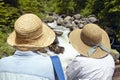 Twin straw hats, two women enjoy creek in Payette National Forest near McCall Idaho Royalty Free Stock Photo