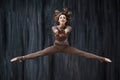 Twine in a jump. Young woman gymnast, fitness and stretching trainer shows sport exercises