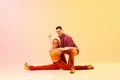 On twine. Support. Expressie, talented young couple, man and woman in vintage clothes dancing against gradient pink