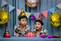 Twins adorable boy in shirt, celebrating his birthday, blowing candles on homemade baked cake, indoor. Birthday party for kids Royalty Free Stock Photo