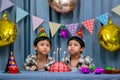 Twins adorable boy in shirt, celebrating his birthday, blowing candles on homemade baked cake, indoor. Birthday party for kids Royalty Free Stock Photo