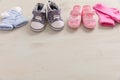 Baby boy and girl shoes and socks on wooden background Royalty Free Stock Photo