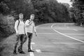 Twins men at edge of road nature background. Try to stop some car. Reason people pick up hitchhikers. Missed their bus Royalty Free Stock Photo