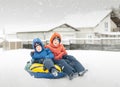 Twins play snowfall time with the inflatable sledge, snow tube