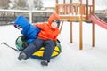 Twins play snowfall time with the inflatable sledge