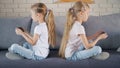 Twins in quarrel playing games on smartphones Royalty Free Stock Photo