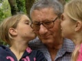 Twins, sisters kiss to grandfather Royalty Free Stock Photo