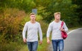 Twins walk along road. Adventure concept. Guys hitchhiking on road. Tourist traveler travel auto stop. Transporting