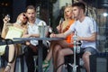 Twins women and men relax in shisha cafe outdoor