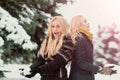 Twins women playing snowballs in forest on snow park. Girls with smiling outdoors on winter day. Christmas and new year Royalty Free Stock Photo