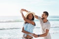 Twirling to the summer breeze. a young couple dancing together at the beach. Royalty Free Stock Photo