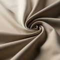 Twisted beige fabric creates a spiral pattern. The smooth texture and soft folds emphasize the Royalty Free Stock Photo