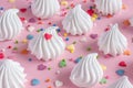 twisted meringues with confectionary decorations on pink background.