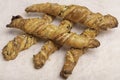 Twisted puff pastry sticks on white paper parchment