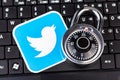 Twitter account password security simple abstract concept. Twitter service logo and a metal coded padlock, lock laying on a black Royalty Free Stock Photo