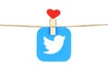 Twitter logo, printed on paper, hangind on a rope with red heart