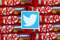 Twitter paper logo on many Kit Kat chocolate covered wafer bars in red wrapping. Advertising chocolate product in Twitter social