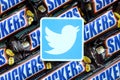 Twitter paper logo on many Snickers chocolate covered wafer bars in brown wrapping. Advertising chocolate product in Twitter