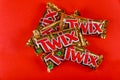 Twix brand candy in large bars with caramel and milk chocolate made by Mars, Inc. on red background
