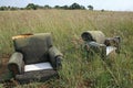 TWO ABANDONED EASY CHAIRS IN LONG GRASS Royalty Free Stock Photo