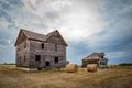 Two abandoned homes, hay bales and a classic car in Robsart, Saskatchewan Royalty Free Stock Photo