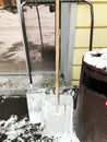 Two abandoned shovels for snow removing leaning against the wall